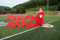 student standing next to 2021 sign