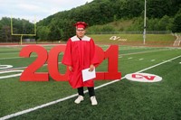 student standing next to 2021 sign