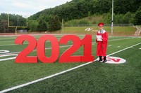 student standing next to 2021 sign