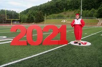 student standing next to 2021 sign