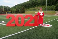 student standing next to 2021 sign