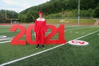 student standing next to 2021 sign