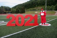 student standing next to 2021 sign