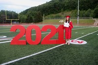 student standing next to 2021 sign