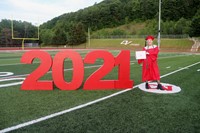 student standing next to 2021 sign