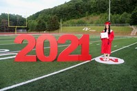 student standing next to 2021 sign