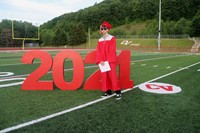 student standing next to 2021 sign