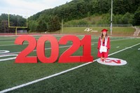 student standing next to 2021 sign