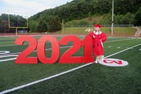 student standing next to 2021 sign