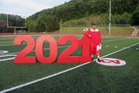 student standing next to 2021 sign