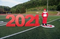 student standing next to 2021 sign