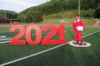 student standing next to 2021 sign