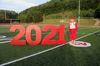 student standing next to 2021 sign