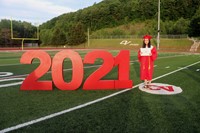 student standing next to 2021 sign