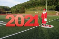 student standing next to 2021 sign