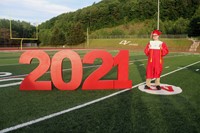 student standing next to 2021 sign