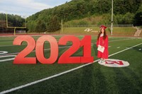 student standing next to 2021 sign