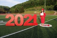 student standing next to 2021 sign