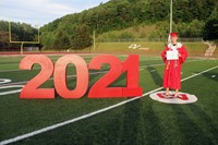 student standing next to 2021 sign