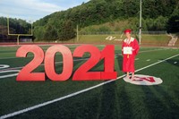 student standing next to 2021 sign