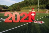 student standing next to 2021 sign