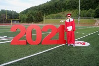 student standing next to 2021 sign