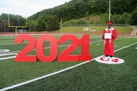 student standing next to 2021 sign