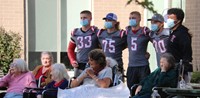 football players taking pictures with residents