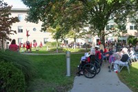 wide shot of nursing home residents watching cheerleaders perform