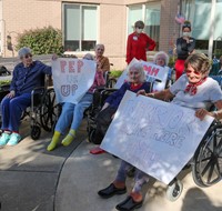 nursing home residents holding up signs
