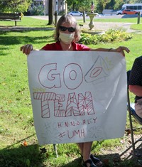 nursing home resident holding up sign