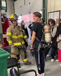 student trying on fire fighter gear