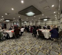 wide shot of Peg Peters speaking at event