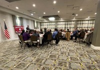 wide shot of Jared Kraham speaking at event