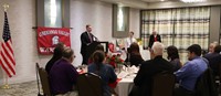 wide shot of Jared Kraham speaking at alumni recognition event