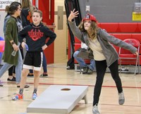 students playing corn hole at community night