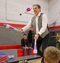 teacher juggling on unicycle