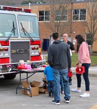 People talking to port dickinson firefighter at booth