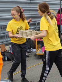 students carrying clay creations