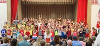 first grade students singing at sing along event