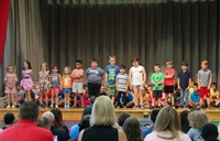 first grade students singing at sing along event
