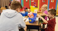 kindergarten student reading to high school student