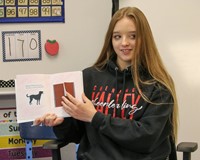 high school student reading to kindergarten students