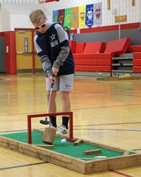 student playing mini golf