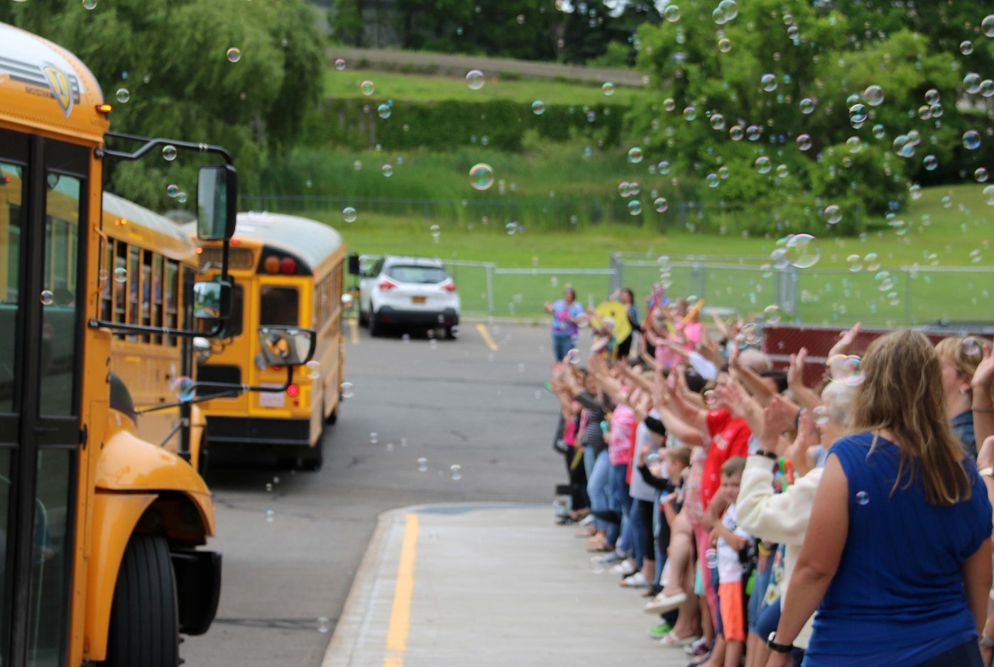 teachers waving goodbye to students