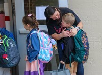 students hugging teacher