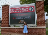 student in front of marquee